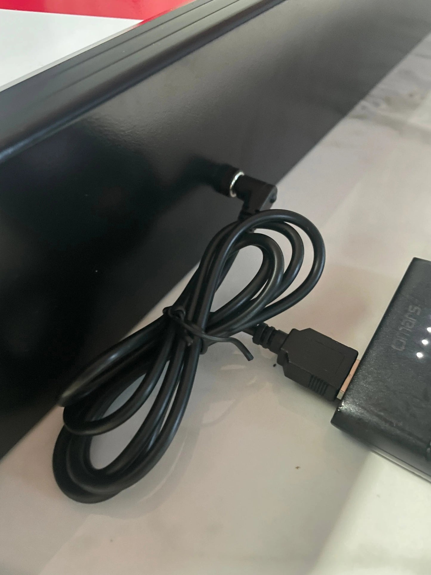10 Second challenge - Black power adapter with cable on a white surface