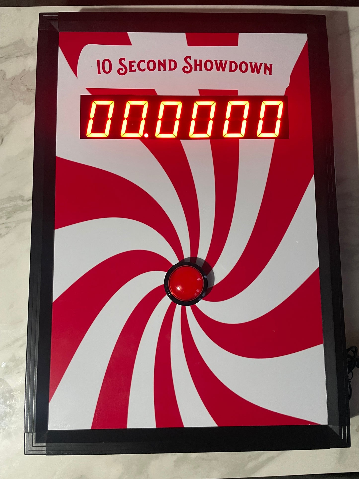 10 Second challenge - Digital timer with red and white spiral design on a marble surface