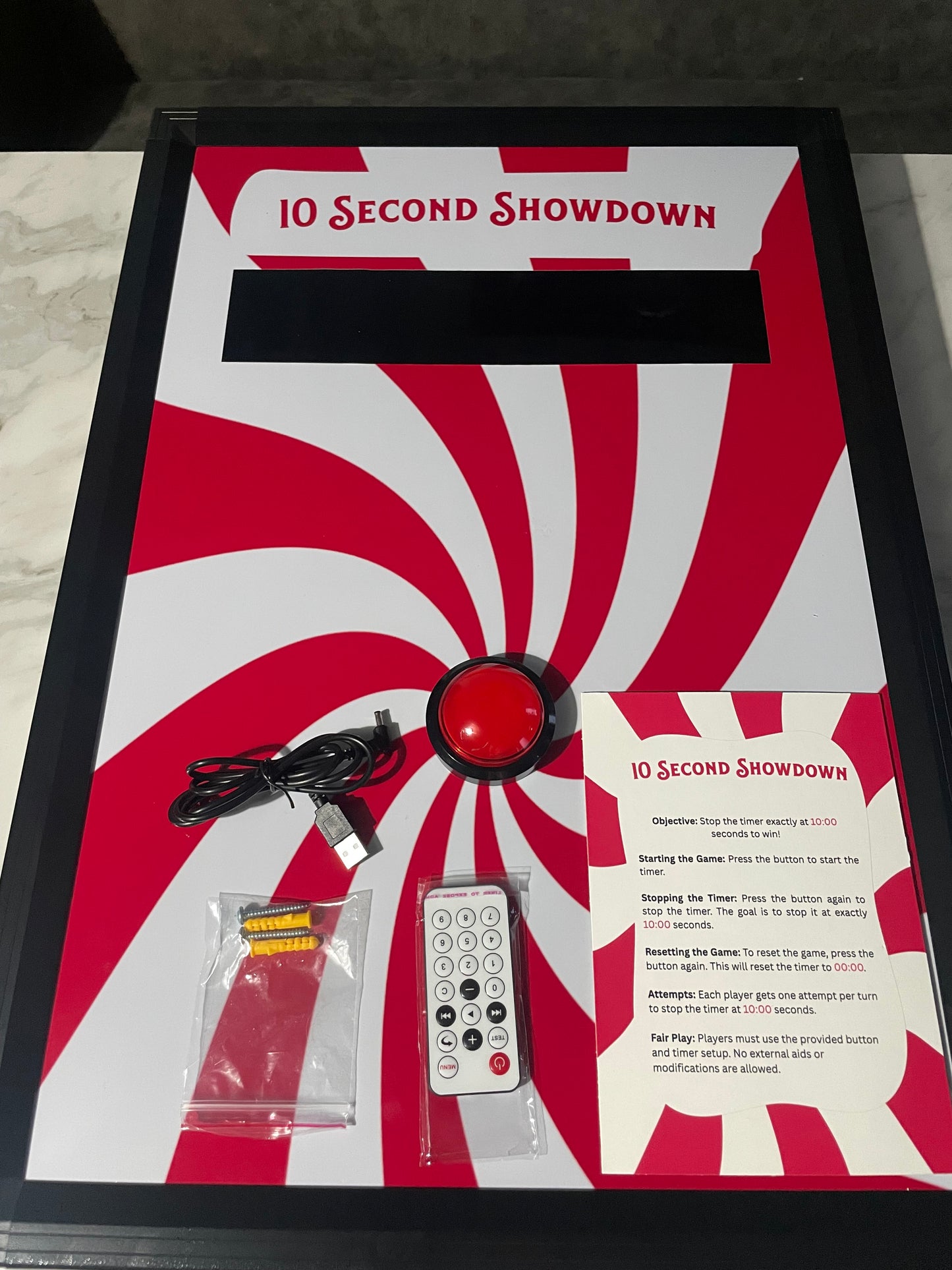 10 Second challenge - Product packaging with red and white design, featuring a remote control and cables on a white background.
