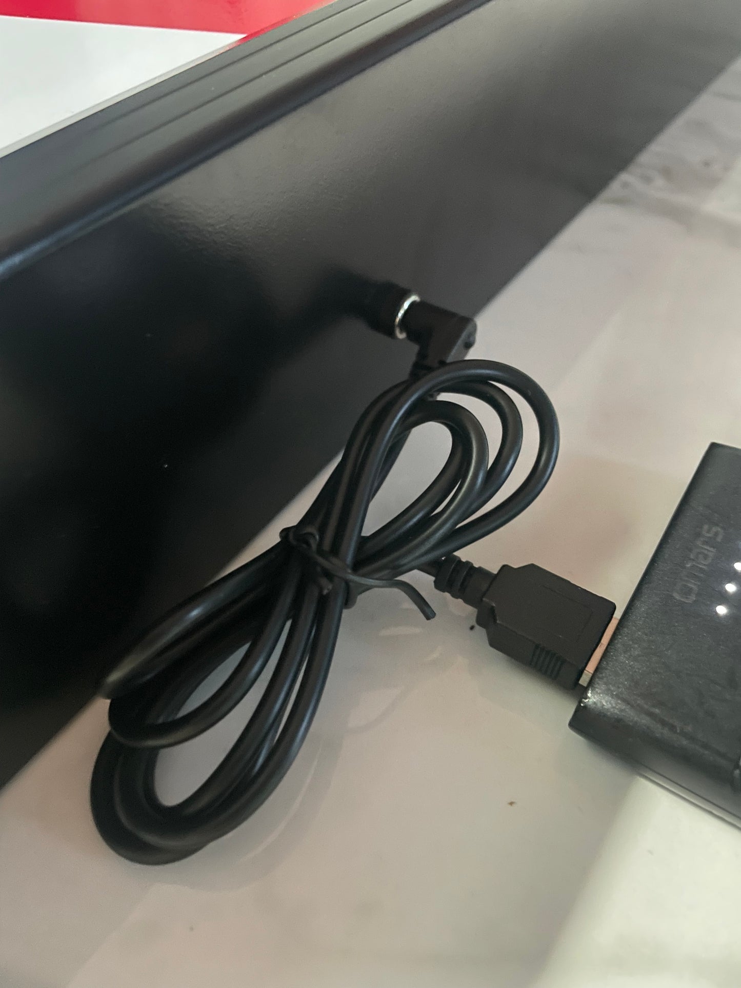 10 Second challenge - Black power adapter with cable on a white surface