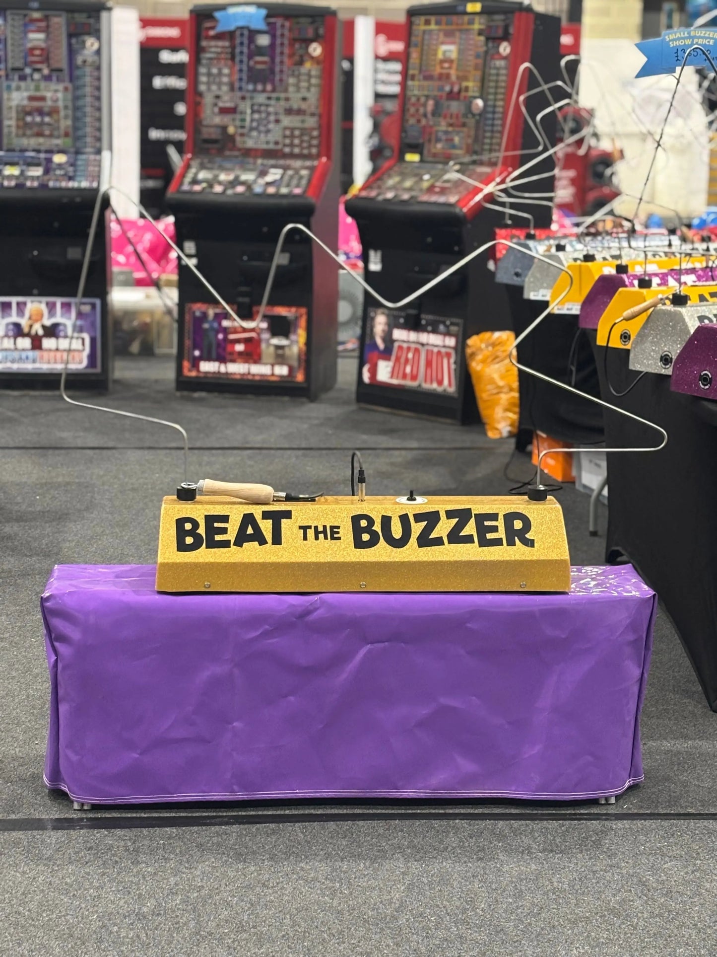 Game show buzzer system on a purple table with arcade games in the background