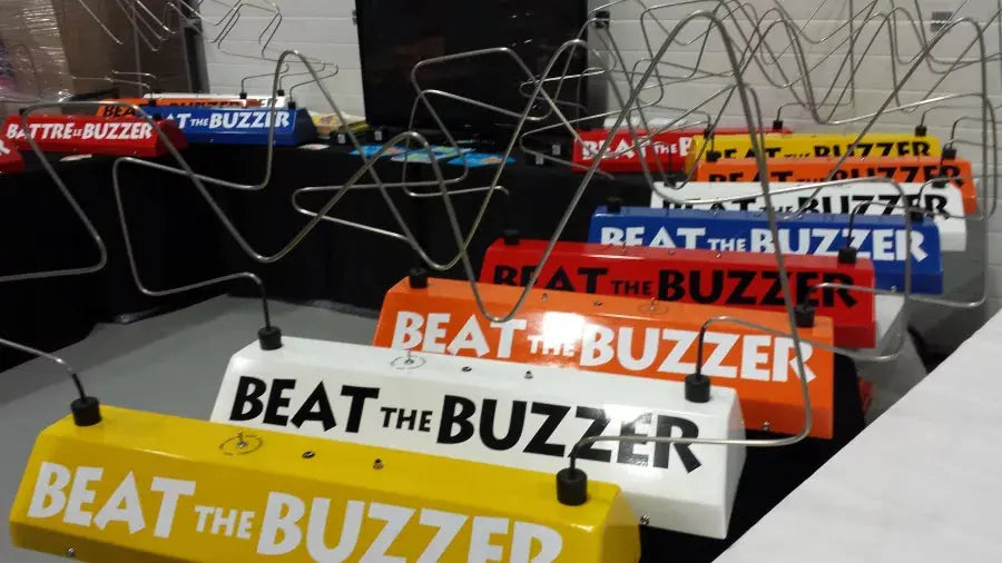 Multiple 'Beat the Buzzer' game buzzers on a table with a blurred background