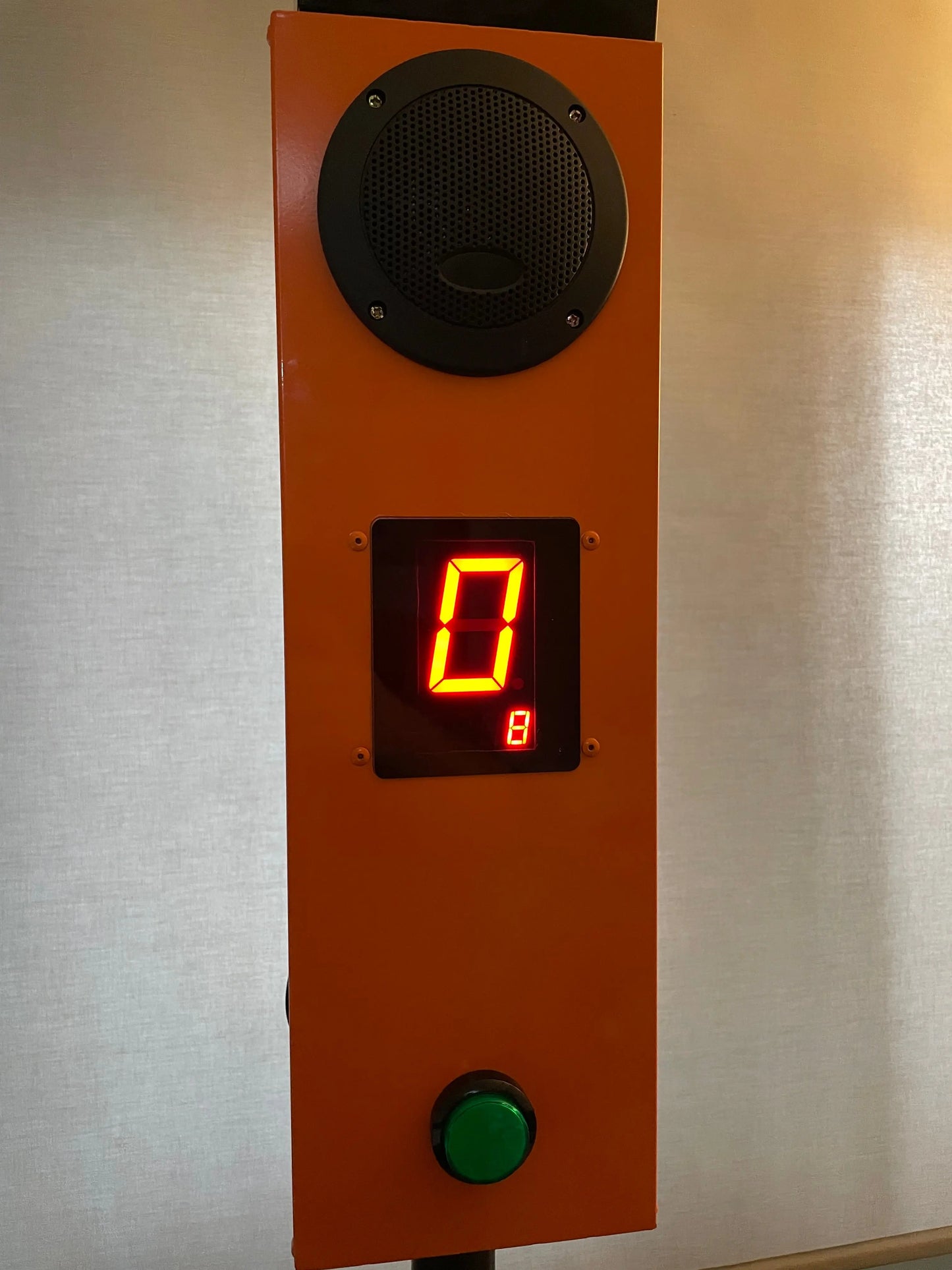 Catch It / Falling Sticks control panel with speaker, digital display, and green button on an orange background