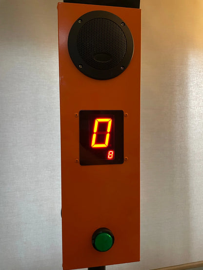 Catch It / Falling Sticks control panel with speaker, digital display, and green button on an orange background