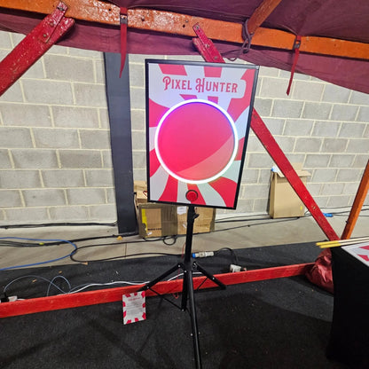 Pixel Hunter target board on a stand with a red and white design, under a maroon canopy.