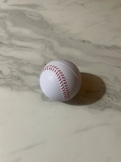 White baseball with red stitching on a marble surface
