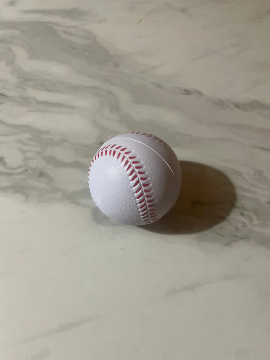 White baseball with red stitching on a marble surface