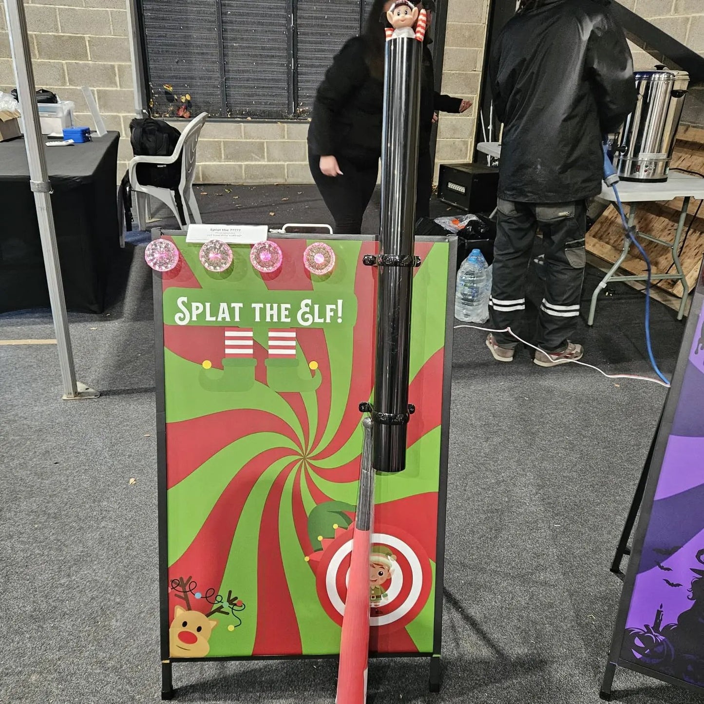 Splat the Elf game setup with a target and red pole in an indoor setting.