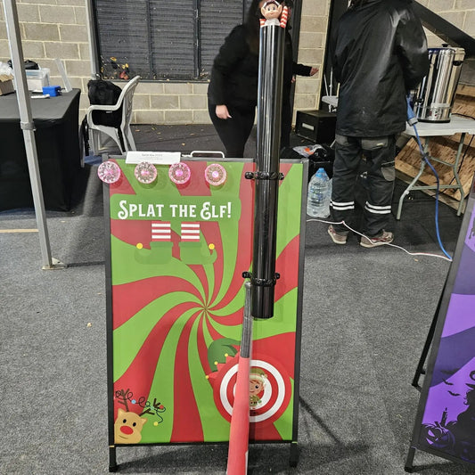 Splat the Elf game setup with a target and red pole in an indoor setting.